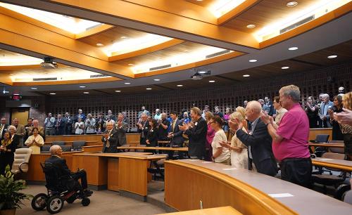 a photo of marcy graham being applauded by a room full of people